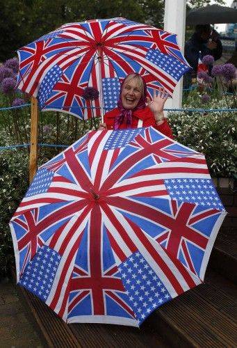 Shirley Honey poses for a photograph as she shelters from a rain shower near Tower Bridge in London