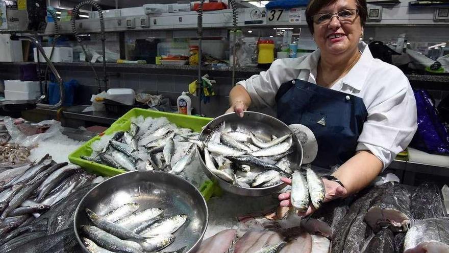 Una pescadera del mercado de la plaza de Lugo enseña la sardina.
