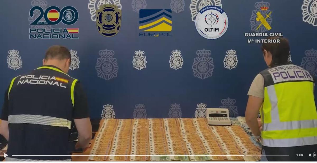 Dos agentes, con parte del dinero intervenido a los sospechosos.
