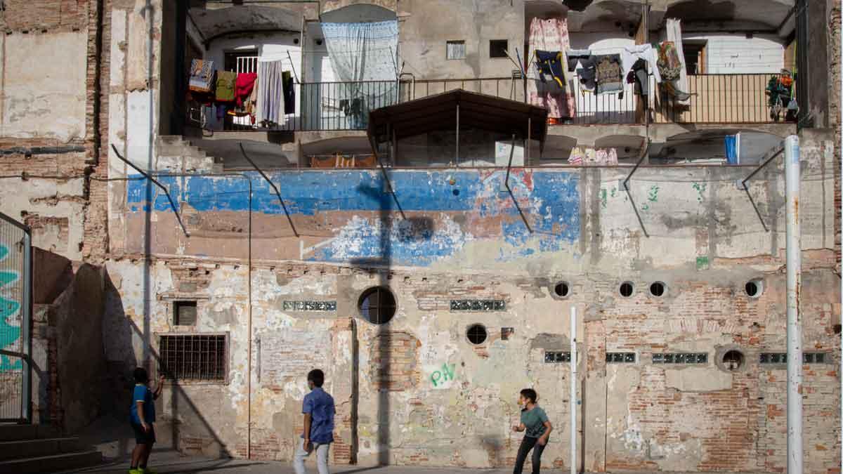 Unos niños juegan junto a una finca del barrio del Raval, en Barcelona