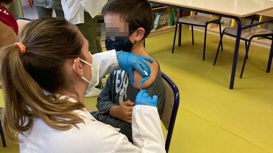 Un enfermera administra una vacuna a un niño en un colegio