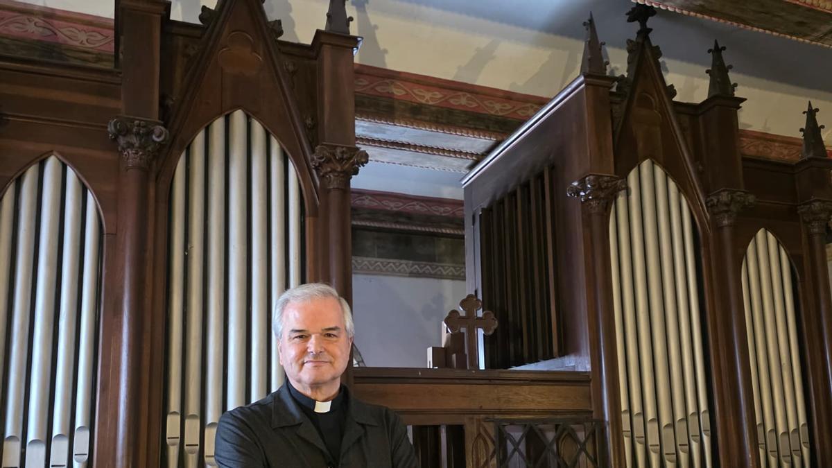 El párroco de San Nicolás de Bari, José Juan Hernández Deniz, ante el órgano de la iglesia.