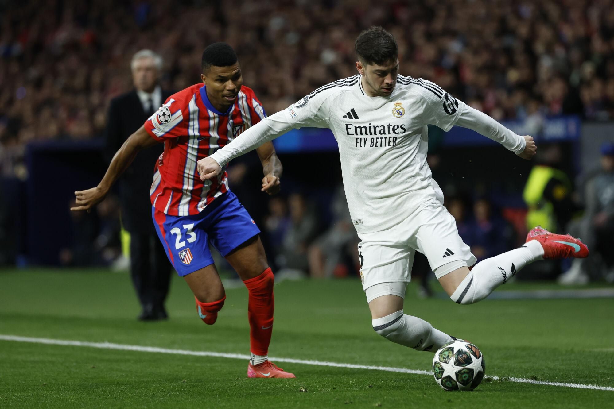 MADRID, 12/03/2025.- El centrocampista uruguayo del Real Madrid Fede Valverde (d) se escapa de Reinildo Mandava, del Atlético de Madrid, durante el partido de vuelta de los octavos de final de la Liga de Campeones que Atlético de Madrid y Real Madrid disputan hoy miércoles en el estadio Metropolitano. EFE/Juanjo Martín