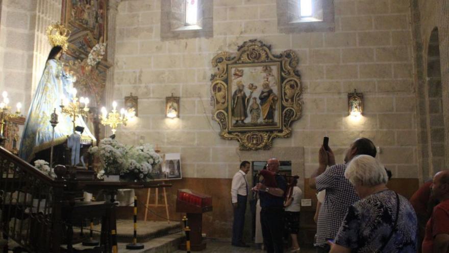 Arriba, varios devotos ante la imagen de la Virgen de los Remedios en el interior de su santuario, en Otero de Sanabria. Abajo, varios feligreses a las puertas del templo. | Araceli Saavedra