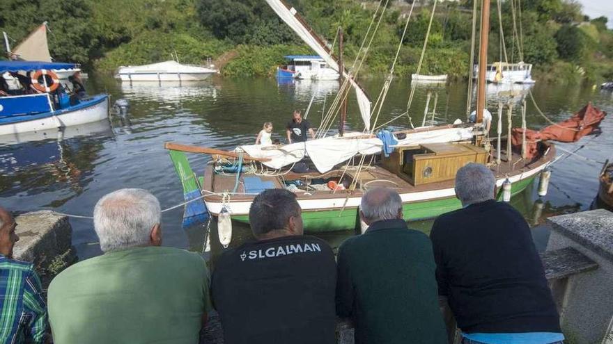 Asistentes a una exposición de embarcaciones antiguas en el puerto de Betanzos.