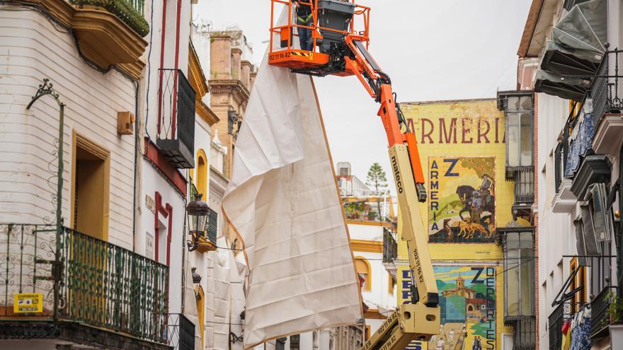 Trabajador instalando los toldos en la calle Sierpes de Sevilla.