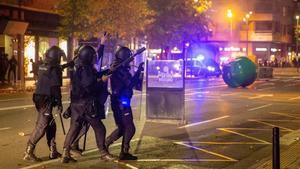 GRAF2036. LOGROÑO, 31/10/2020.- Unos 150 radicales, muchos de ellos jóvenes, han protagonizado esta tarde-noche disturbios en el centro de Logroño, donde han cruzado y quemado contenedores, han tirado piedras y botellas de crisital a la Policía y han cortado el tráfico en las cercanías del Ejecutivo riojano y de la Delegación del Gobierno en La Rioja. En la imagen, agentes antidisturbios intentan controlar la zona. EFE/Raquel Manzanares