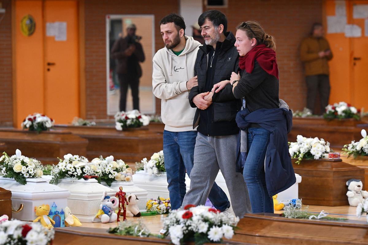 Familiares junto a los ataúdes de las 65 víctimas de un devastador naufragio de inmigrantes frente a la costa sur de Italia