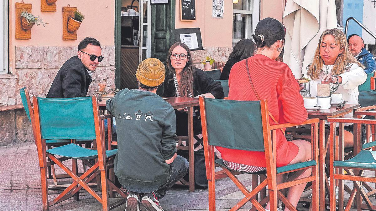 Un camarero atiende a dos clientes en la terraza del bar La Molienda, frente a la Rambla de Palma.