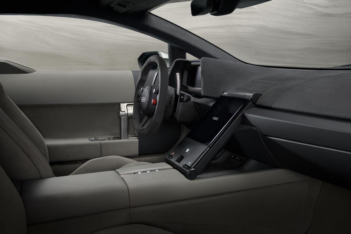 Tiene un interior minimalista centrado en el conductor, con interfaz digital HMI, materiales ligeros de carbono y una distribución clara que prioriza la información esencial y la ergonomía.