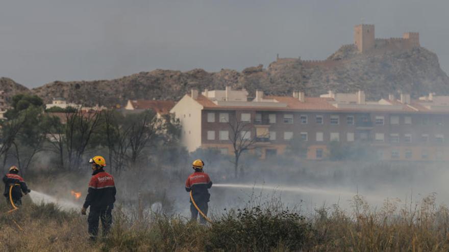 Bomberos apagando las llamas este sábado por la tarde junto al casco urbano de Sax.