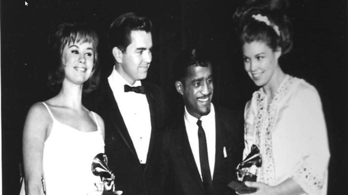 Creed Taylor, en el centro a la izda. junto al cantante y actor Sammy Davis Jr., recoge el premio para el álbum 'Getz/Gilberto', que incluía 'La chica de Ipanema', acompañado de Astrud Gilberto (izda.) y Monica Getz (mujer de Stan Getz, dcha.) en la entrega de los Grammy de 1964.