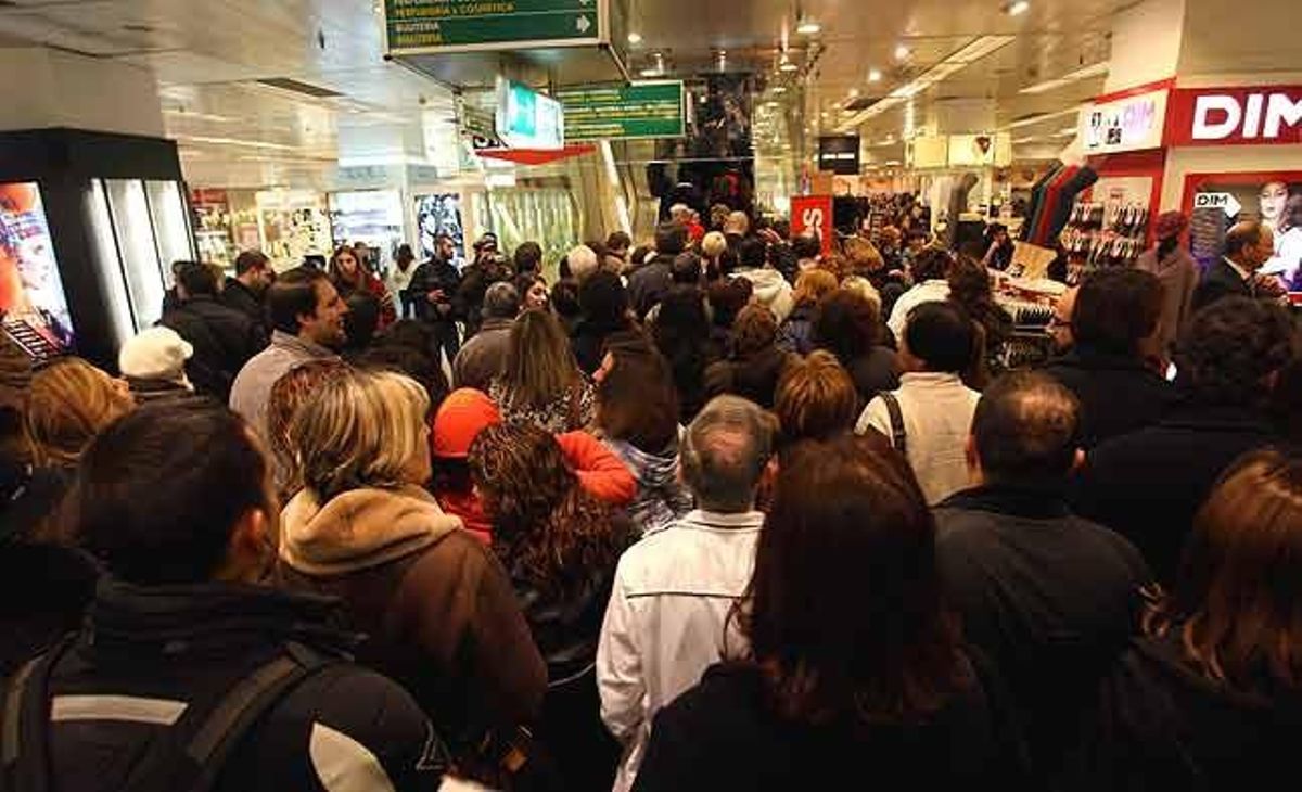 Compradors esperen el seu torn per pujar les escales mecàniques d’El Corte Inglés, durant el primer dia de rebaixes a Barcelona.