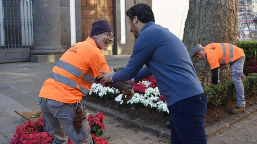 Luis Yeray Gutiérrez saluda a uno de los operarios que colocan flores de pascua en el entorno de la Catedral. | | E.D.