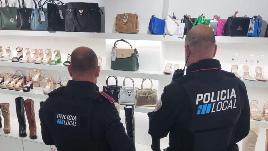 Agentes de la Policía Local durante la intervención de artículos falsificados en dos comercios de Palma.