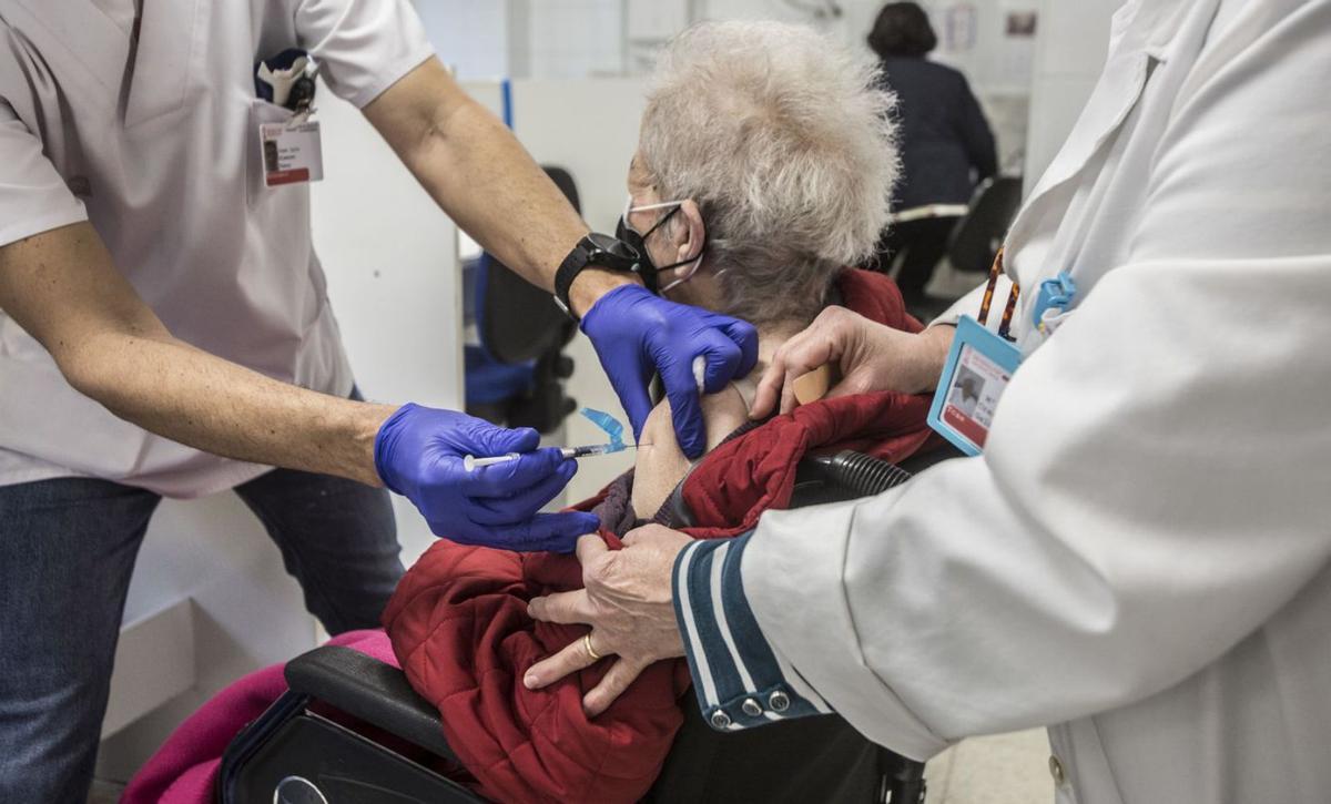 Sanitarios ponen una dosis de la vacuna contra el coronavirus a una mujer.