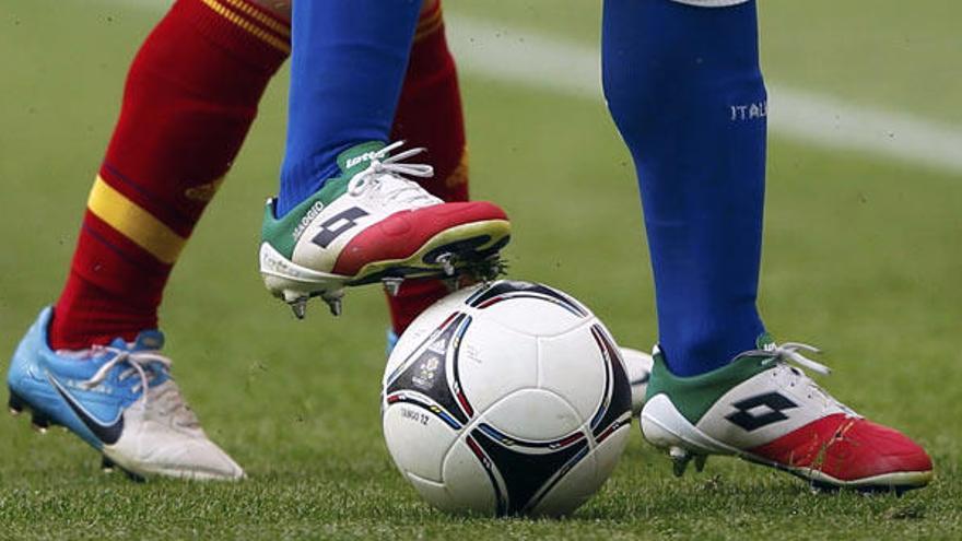 Detalle de las botas de Maggio e Iniesta pugnando por una pelota sobre el césped de Gdansk.