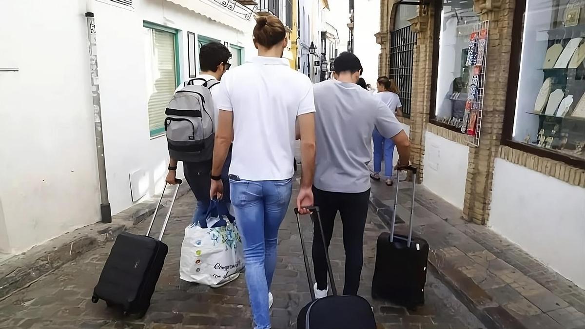 Un grupo de turistas con maletas en el casco histórico.
