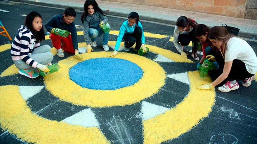 Varios niños preparan una alfombra floral. // Rafa Vázquez