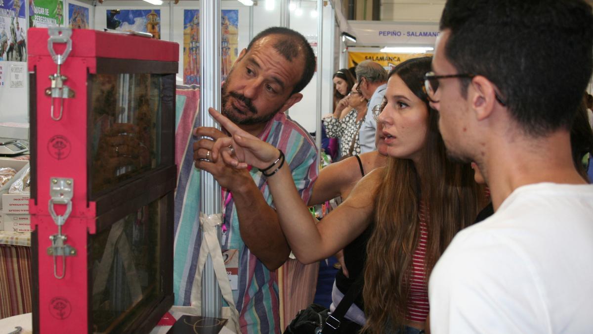 Alejandro Solano mostraba un cuadro de abejas de una colmena a un grupo de visitantes que acudían a su stand de miel.