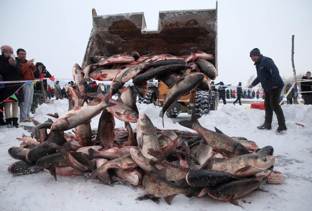 Gente participando en el evento invernal de pesca en Changchun, China.