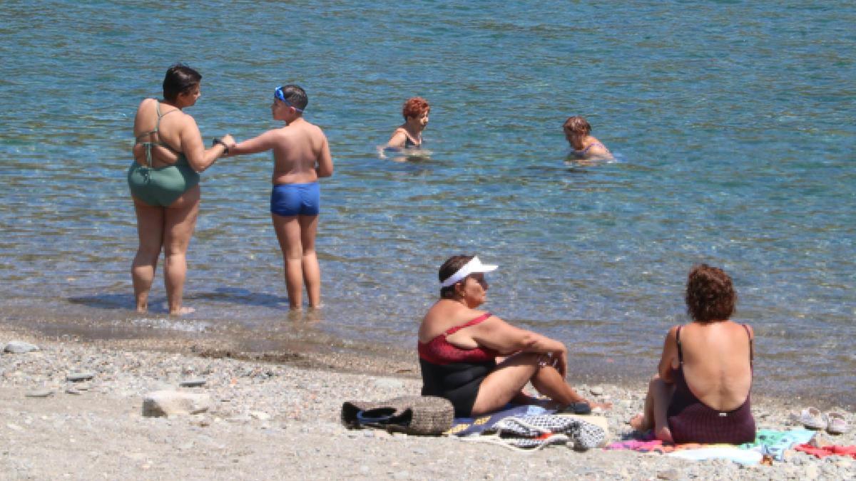 Diverses persones a la platja de Portbou.