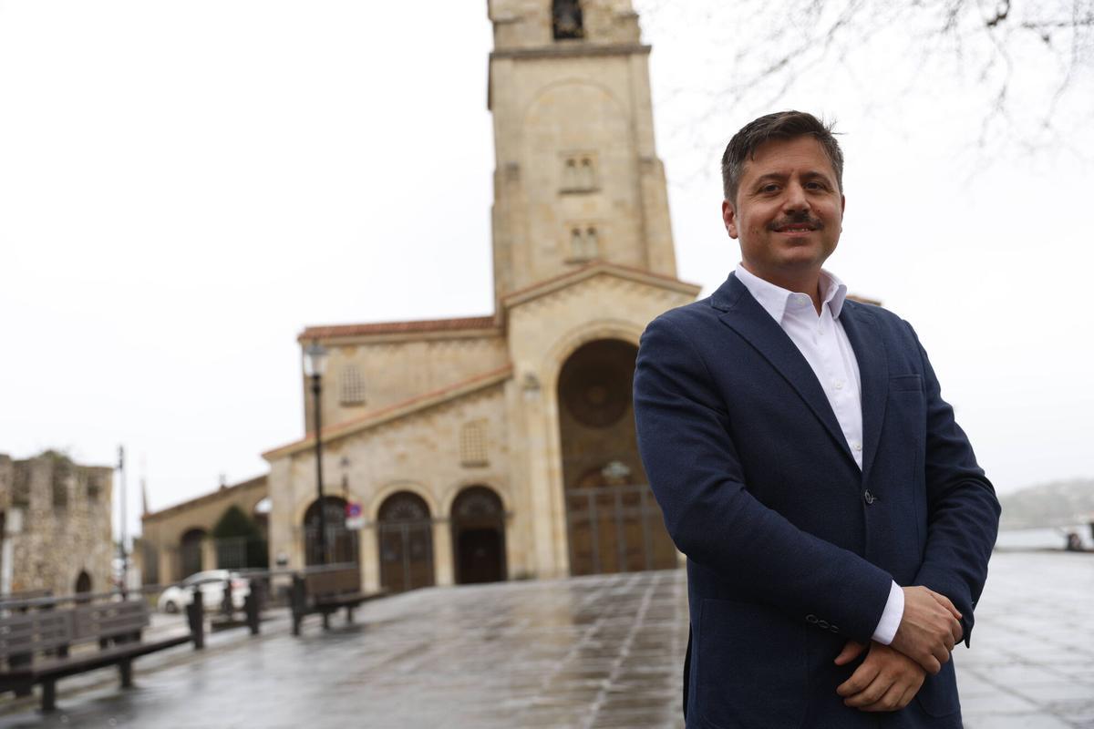 Eloy Méndez, director de La Nueva España en el Campo Valdés con la iglesia De San Pedro a su espalda