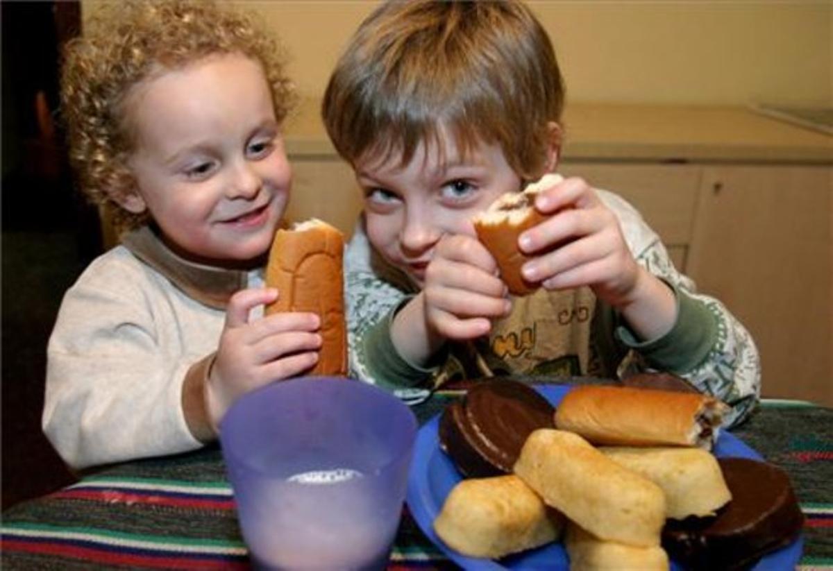 Unos niños ingieren bollería.