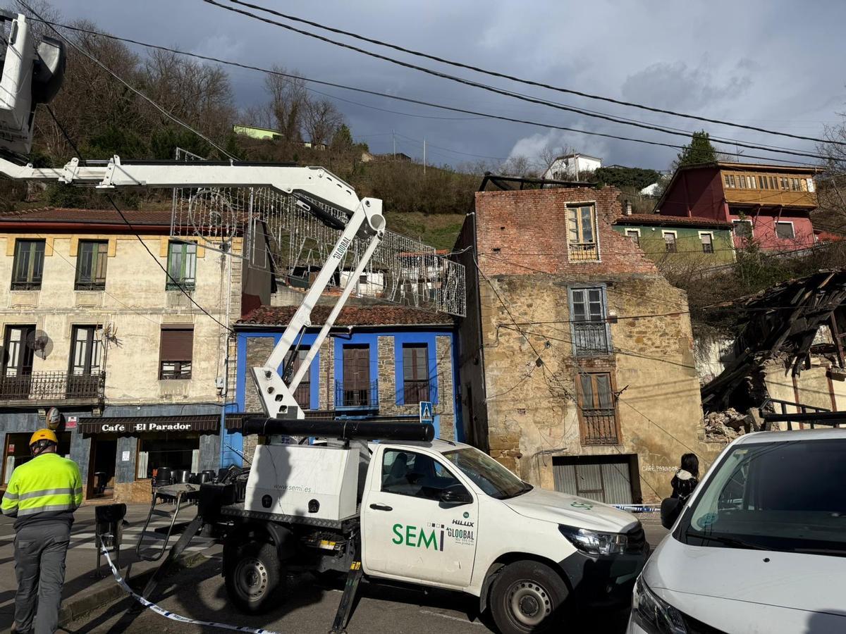 Trabajadores en el entorno del edificio que se vino abajo en Turón, a la derecha de la foto.