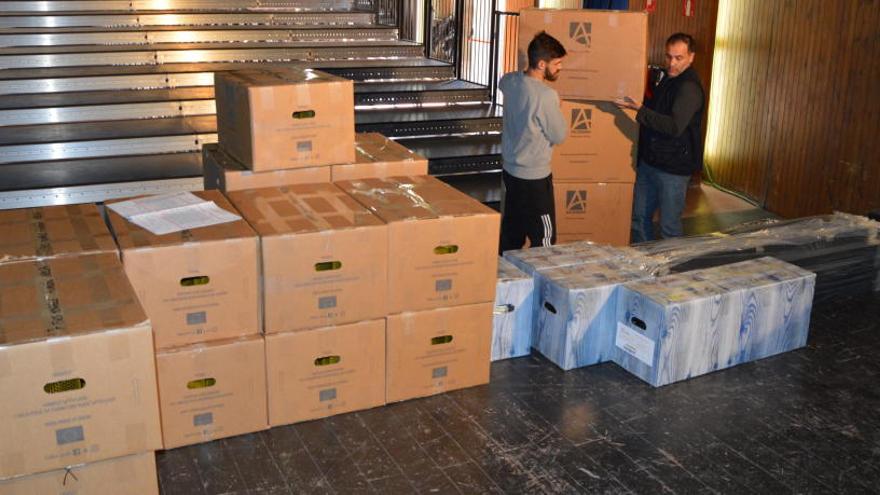 Dos operaris descarregant les caixes amb les peces de les butaques, ahir a la platea del teatre de l&#039;Ametlla.