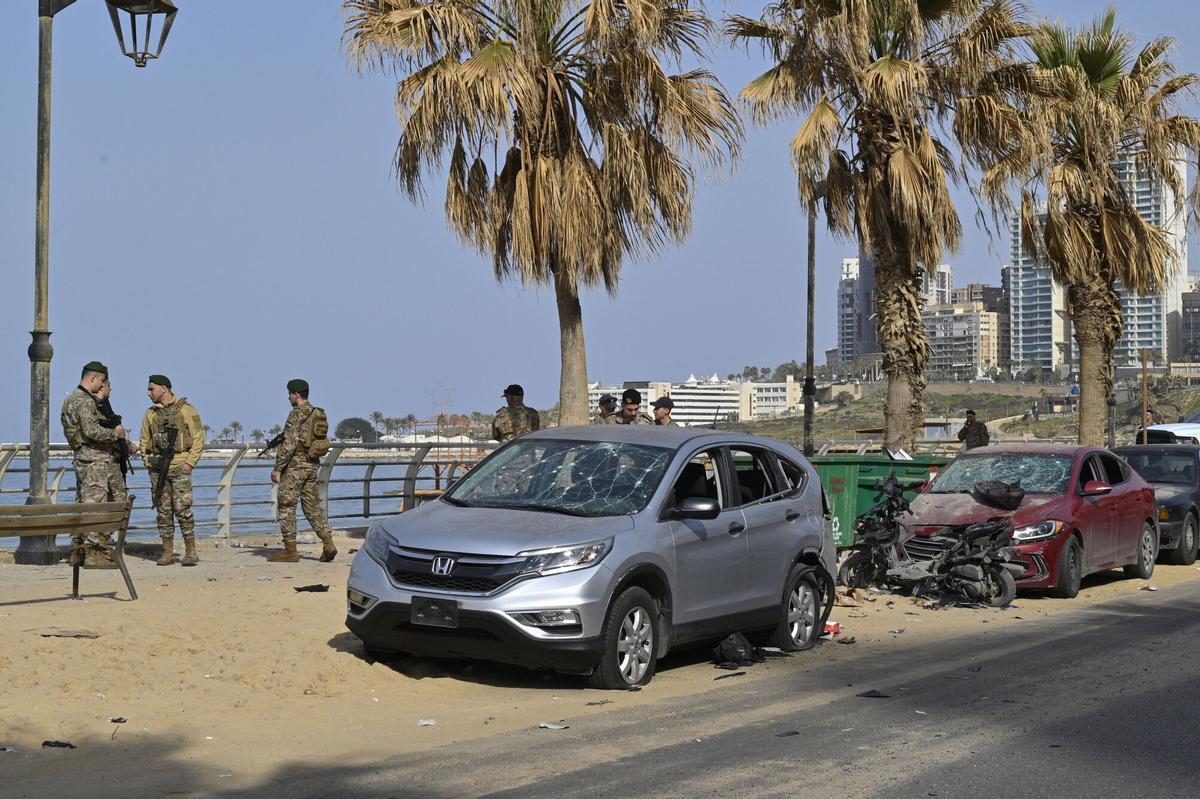 Soldados del ejército libanés se encuentran cerca de vehículos dañados en el lugar de un ataque con drones israelíes en la playa pública de Ramlet Al Bayda en Beirut.