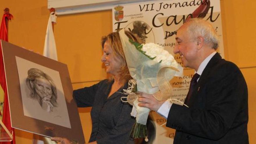 Isabel San Sebastián recibe el retrato de Luis Serrano como premio, con el alcalde de Coaña, Salvador Méndez, a su lado.