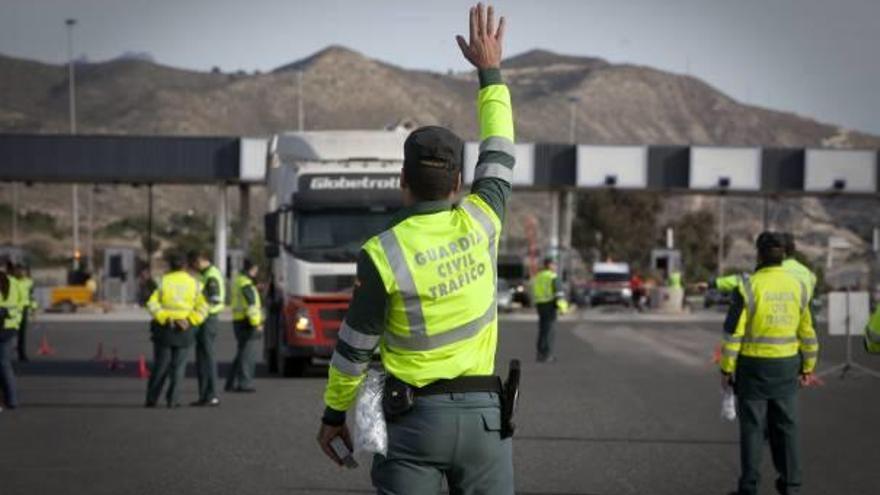 Un guardia civil se dispone a detener a un camión en uno de los accesos a la AP-7.