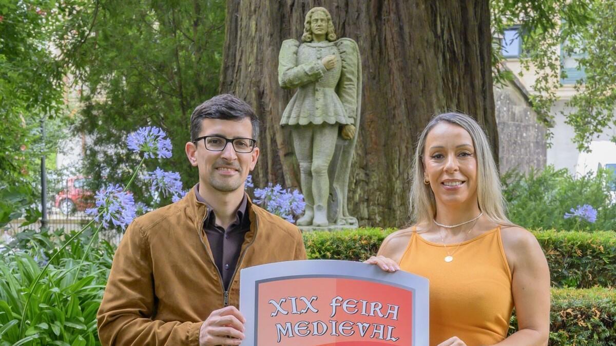 El regidor Anxo Arca y la concejala Chus Campos en la presentación de la Feira Medieval con la estatua de Macías detrás