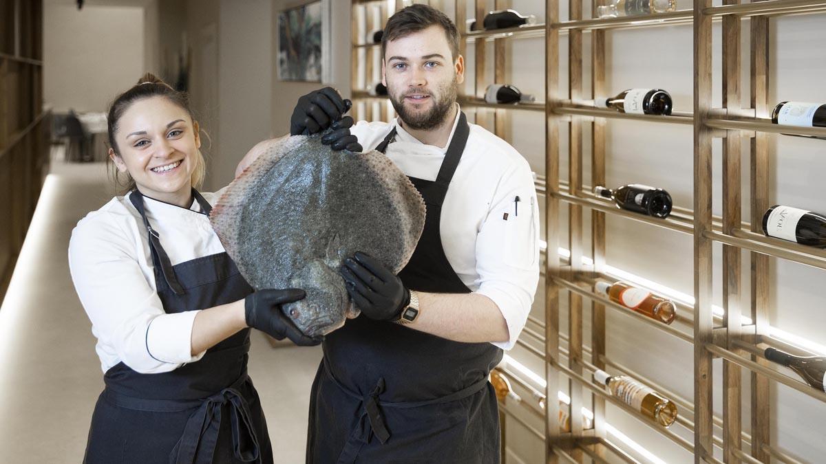  Lena María Grané y Ricky Smith, con un rodaballo en la entrada del restaurante Baló.