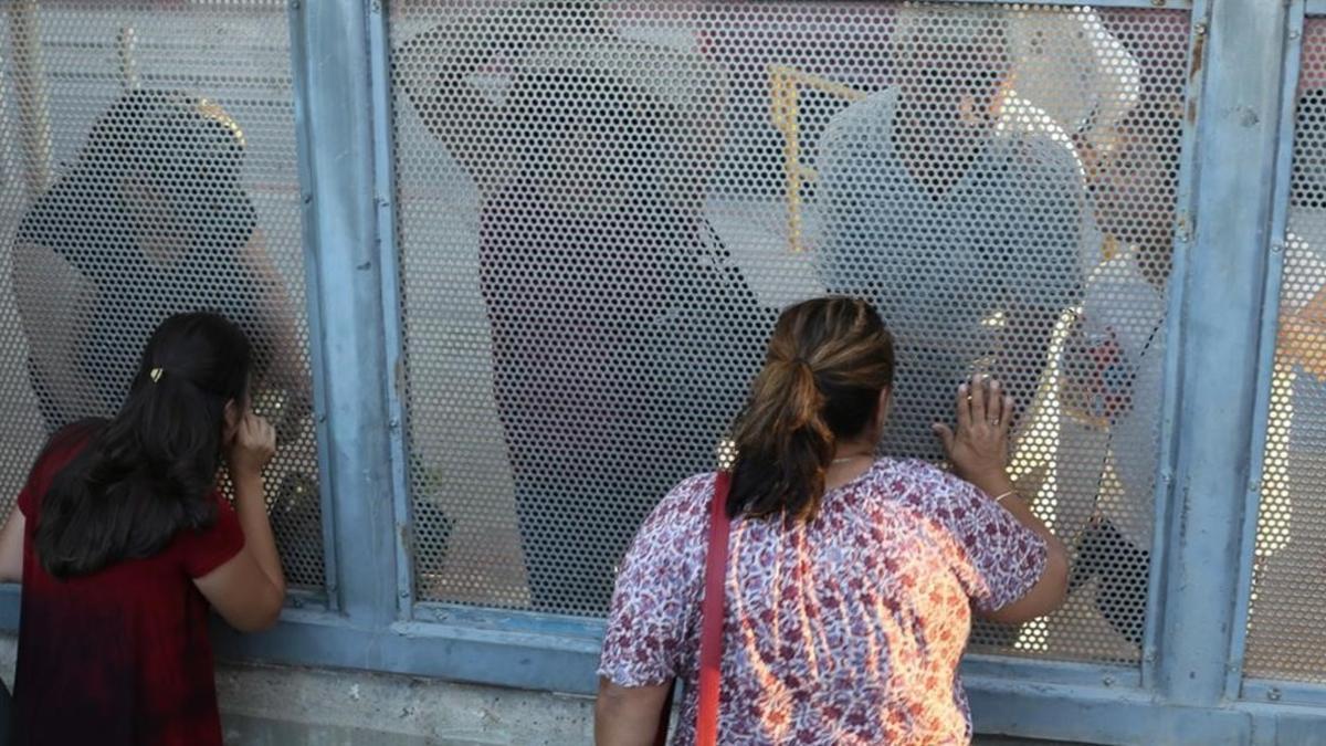 Ana Pineda (a la derecha) habla con sus familiares desde el lado estadounidense de la frontera de Nogales.