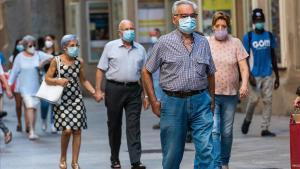 Personas mayores con mascarilla pasean por el Eix Comercial de Lleida, este martes.