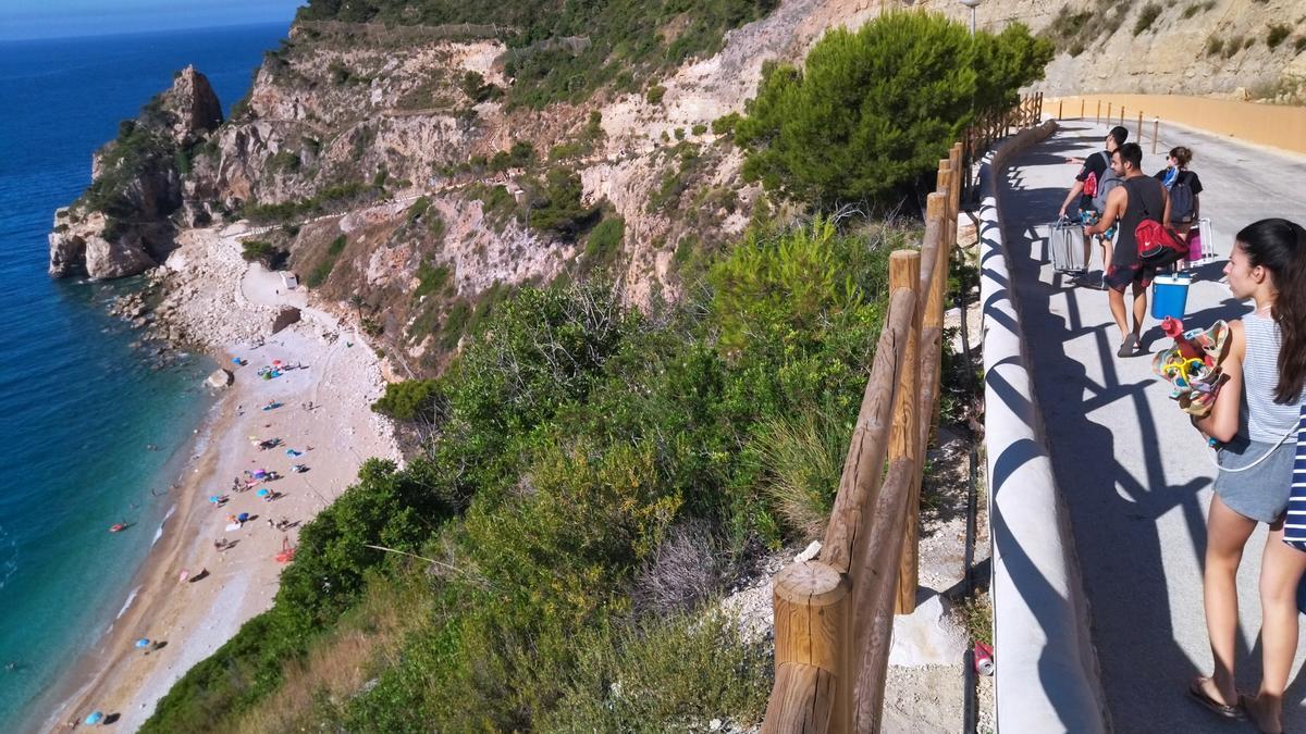 Los bañistas bajan a la cala por un vial de fuerte pendiente cerrado a los coches