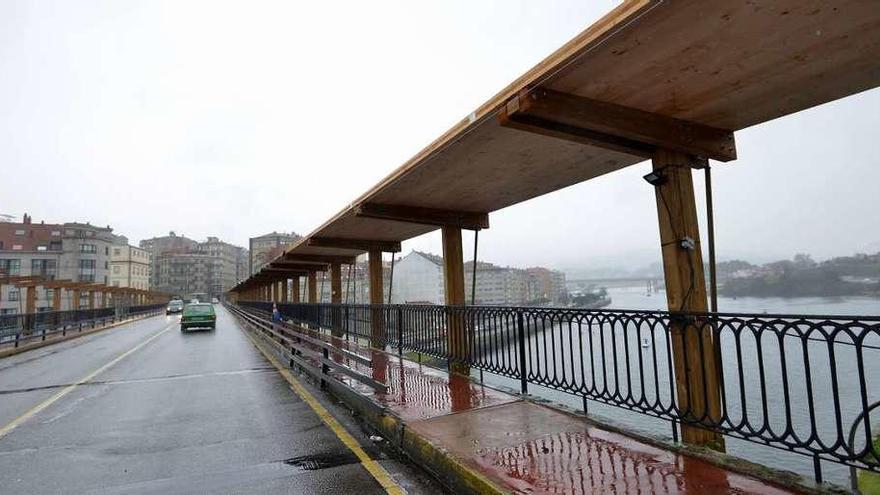 Una fase de la cubierta de madera ya ha comenzado a instalarse sobre una de las aceras del puente. // G. Santos