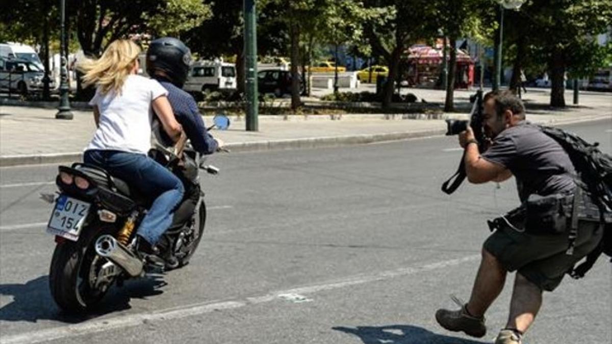 El ministro de Finanzas, Yanis Varoufakis, abandona el ministerio de Finanzas en su moto con su esposa, sin casco, en Atenas, ayer.