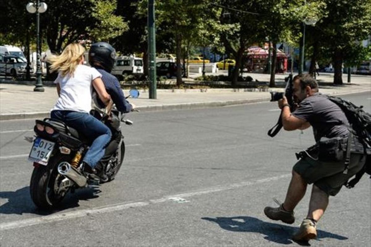 El ministre de Finances, Iannis Varufakis, abandona el ministeri de Finances en la seva moto amb la dona, sense casc, a Atenes, ahir.