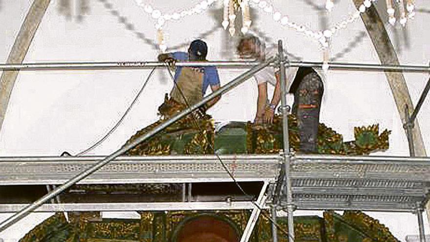 Operarios trabajando en el retablo antes de su desmontaje.