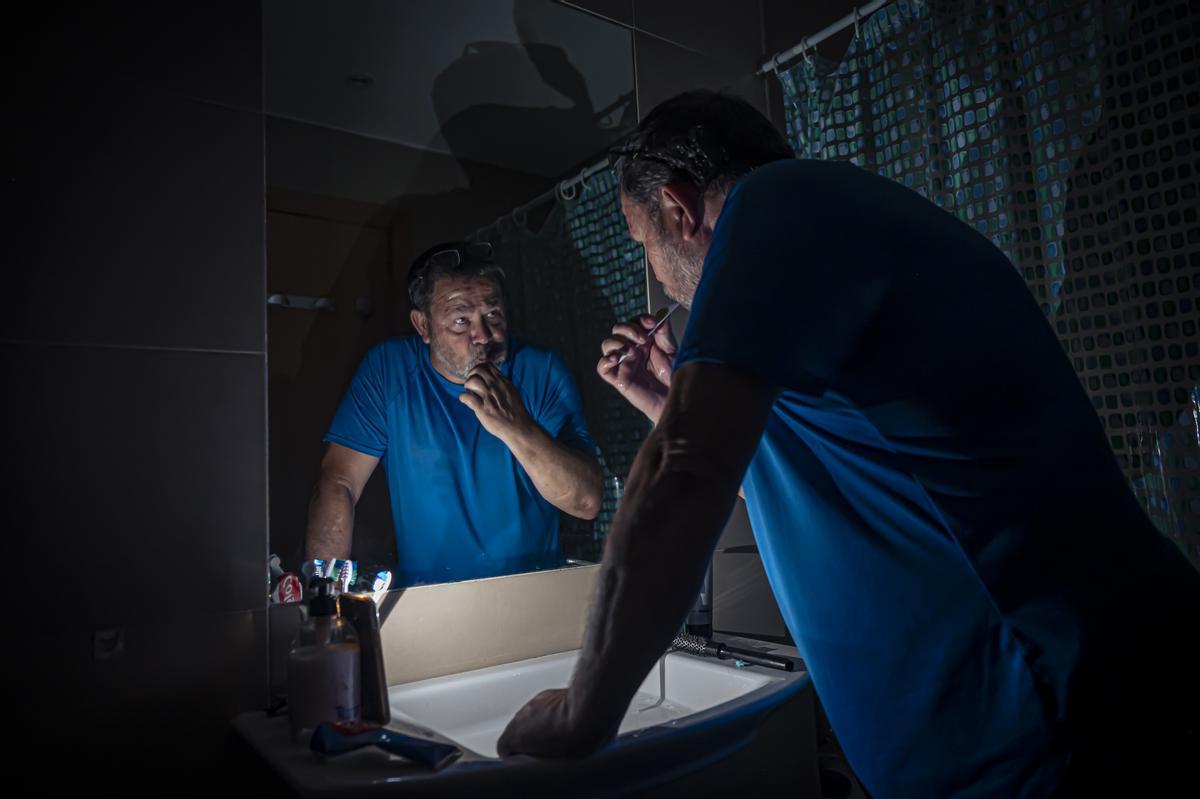Andrés Uceno se lava los dientes a oscuras en el baño, que no tiene ventana