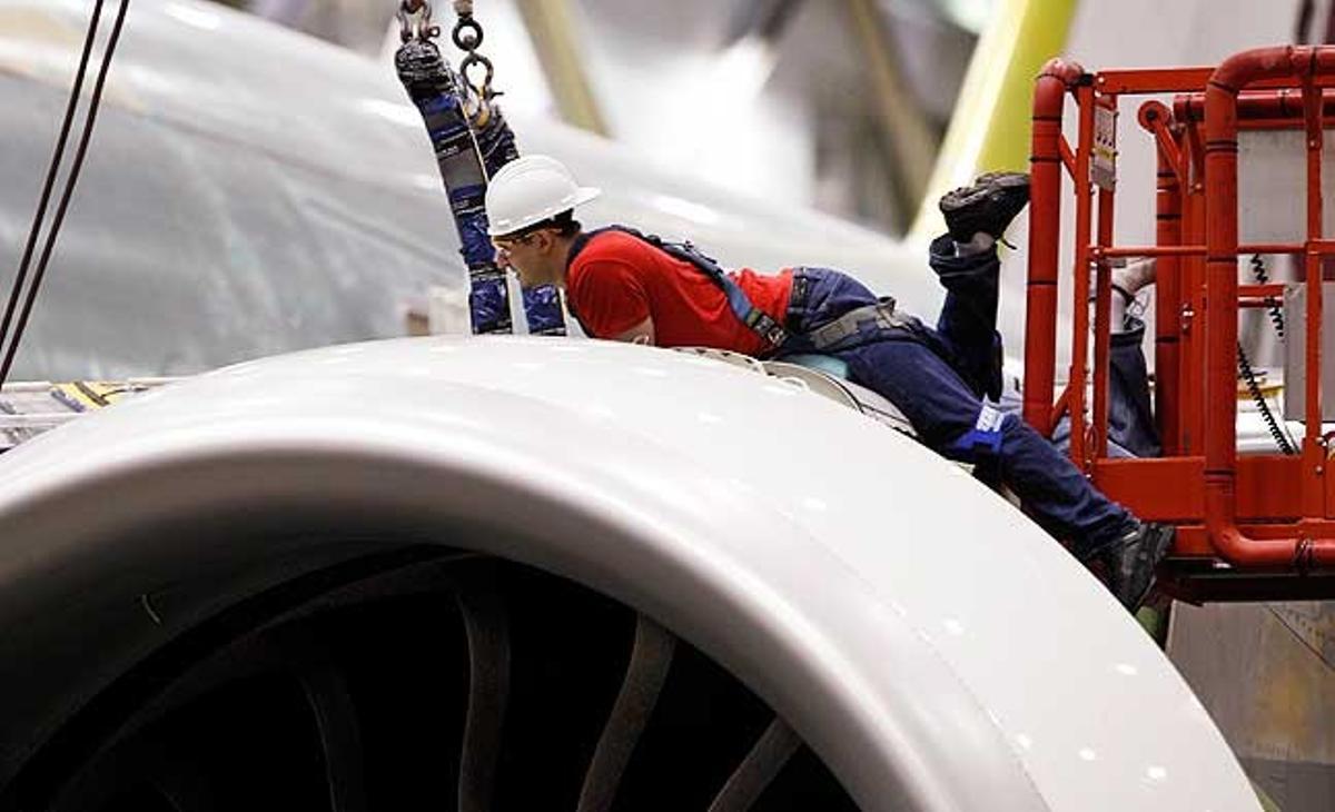 Un treballador opera a sobre d’un motor de l’avió Boeing 777 a la planta de fabricació d’Everett, Estats Units.