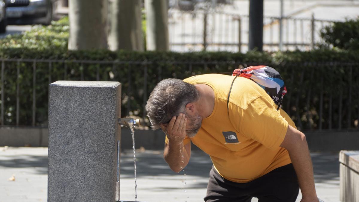 Un hombre se refresca en una fuente pública. Las temperaturas son ya extremas en muchos lugares del país e incluso de madrugada no han descendido de los 30 grados en muchos lugares mientras España se prepara para afrontar, a partir de mañana y al menos hasta el próximo martes.