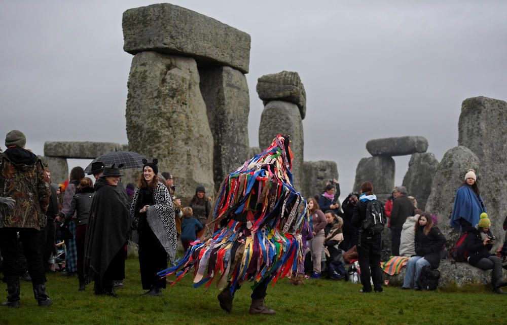 Miles de personas, varias de ellas disfrazadas de druidas, acudieron hoy al monumento de Stonehenge en Inglaterra para ver el amanecer con motivo del solsticio de invierno.