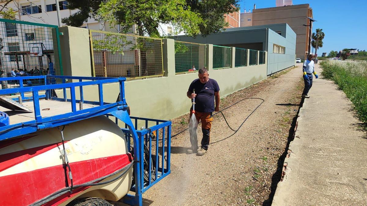 Un operario municipal baldea los alrededores del CEIP Sant Bernat.