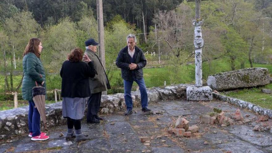 El sacerdote, segundo por la derecha, con otros vecinos, observa varios cascotes caídos. // Noé Parga