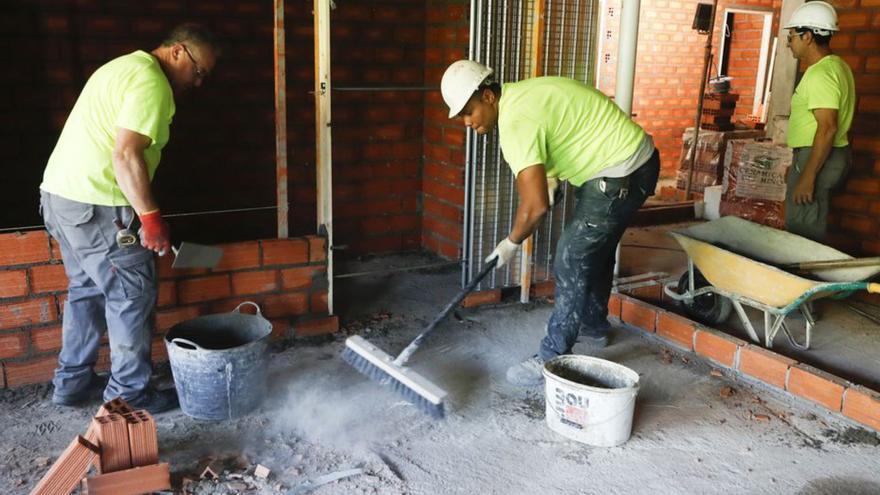 Tres albañiles trabajan en la reforma de una casa. |   // RICARDO GROBAS