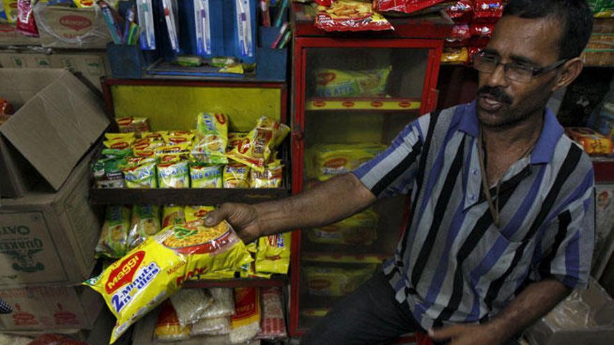 Un vendedor muestra un paquete de noodles de Maggi.